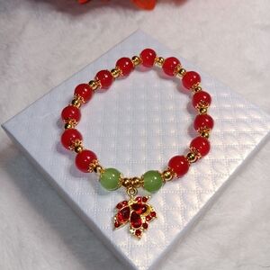 Elegant Red and Green Beaded Bracelet with Gold Accidents And Leaf Charm